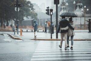 Couple qui se tienant bras dessus bras dessous avec un parapluie